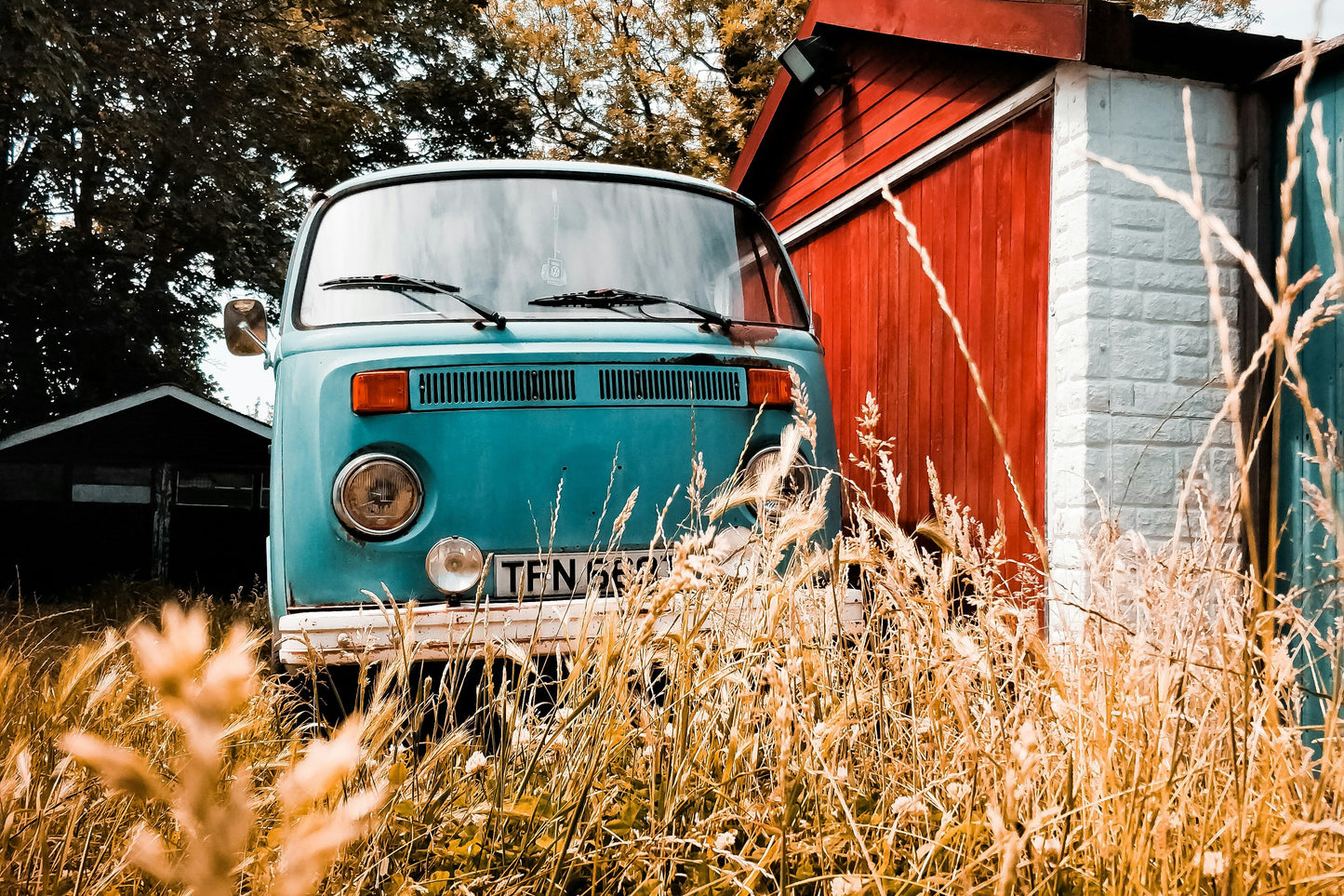 An image of a rad old van hiding behind a barn. Photo credit: Matthew Foulds via Unsplash.com.